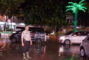 Kapolsek Langsa Kota, AKP Salmidin, saat mengamankan arus lalulintas di Jalan Ahmad Yani di kawasan Lapangan Merdeka Langsa yang terendam banjir, Kamis (4/10/2018). (Foto/dede)