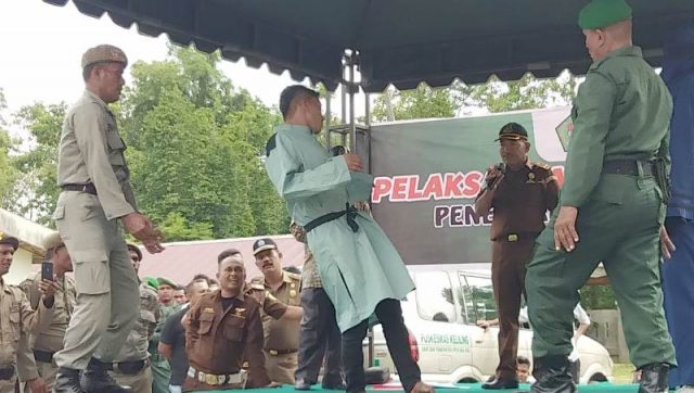 WhatsApp Image 2018-11-15 at 17.12.08 Terhukum tampak hampir roboh saat mendapatkan eksekusi cambuk sebanyak 100 kali di halaman Masjid At-Taqwa, Kecamatan Simpang Tiga, Pidie, Kamis (15/11/2018).(Foto/Muhammad Riza)