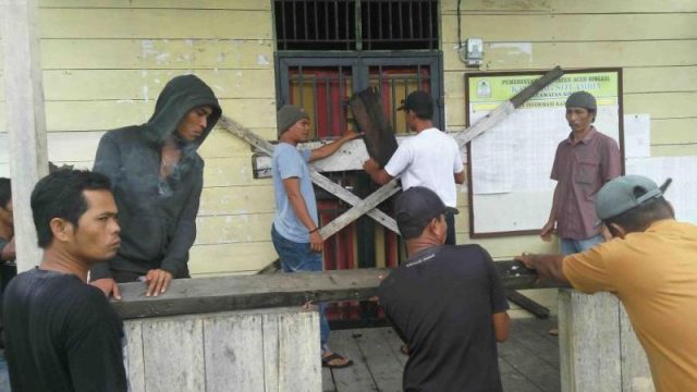 WhatsApp Image 2018-11-23 at 18.49.03 Aksi warga serta aparatur Desa Siti Ambia memasang palang di pintu kantor desa setempat, Jumat (23/11/2018). (Foto/Arief H).