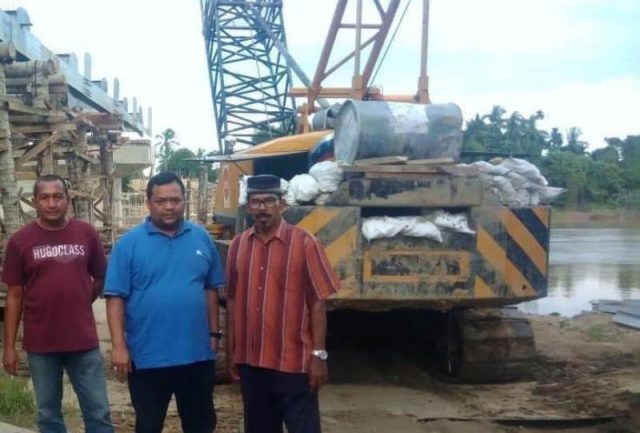 WhatsApp Image 2018-11-25 at 13.15.37 Asrizal Asnawi (kaos biru), anggota DPRA saat meninjau pembangunan lantai jembatan penghubung Kecamatan Seruway – Kecamatan Bendahara, Aceh Tamiang. (Foto/Ist)
