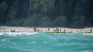 Sekelompok suku terasing di Pulau Sentinel Utara terlihat berjaga-jaga di pinggir pantai pulau itu pada 2005. (Christian Caron - Creative Commons A-NC-SA)