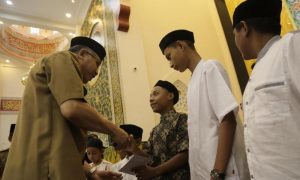Gubernur Aceh, Nova Iriansyah, menyerahkan santunan kepada anak yatim Gampong Lamsepeung. (Foto/Ist)