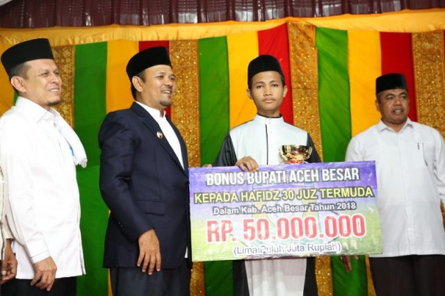 aceh besar Bupati Aceh Besar Ir Mawardi Ali menyerahkan hadiah Rp50 juta juara Hafidz 30 juz termuda Aceh Besar, Muhammad Safwan,19, pada peringatan tahun baru Islam 1 Muharram 1440 H di Masjid Jamik Abu Indrapuri, Senin malam (10/9/2018). (Foto/Ist)