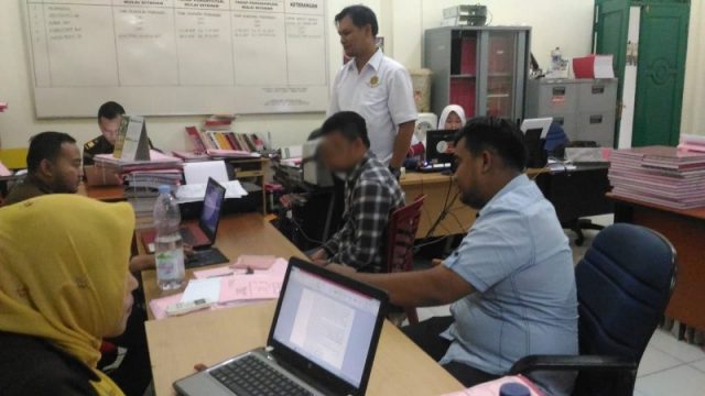 tipu Penyidik Sat Reskrim Polres Aceh Barat, Rabu (12/9/2018), menyerahkan tersangka (baju kotak-kotak) berikut berkas dan barang bukti dalam kasus dugaan penipuan di Rumah Sakit Umum Daerah (RSUD) Cut Nyak Dhien Meulaboh ke Kejaksaan Aceh Barat. (Foto/Ist)