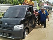 Sejumlah warga Samudera, Aceh Utara, sedang mendorong mobil warga yang mogok saat melintasi banjir di Jalan Lintas Sumatera (Jalinsum), Sabtu (17/11/2018). (Foto/Zainal Abidin)