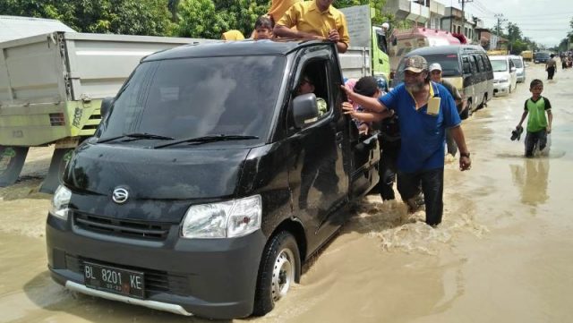 WhatsApp Image 2018-11-17 at 18.13.33 Sejumlah warga Samudera, Aceh Utara, sedang mendorong mobil warga yang mogok saat melintasi banjir di Jalan Lintas Sumatera (Jalinsum), Sabtu (17/11/2018). (Foto/Zainal Abidin)