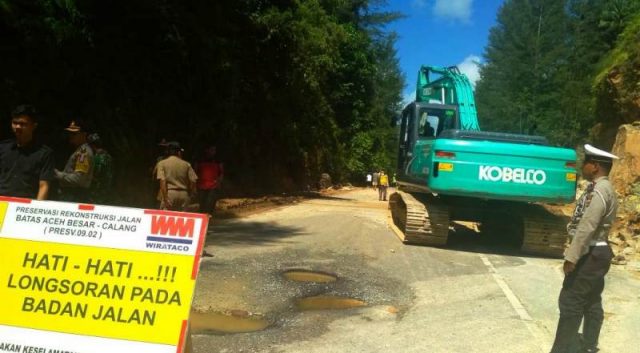 WhatsApp Image 2018-11-23 at 17.56.27 Alat berat memindahkan material longsor batu gunung di lintasan Banda Aceh-Meulaboh tepatnya di kawasan wisata Lhok Geulumpang, Kecamatan Setia Bakti, Aceh Jaya, Jumat (23/11/2018). (Foto/Dedi Iskandar)