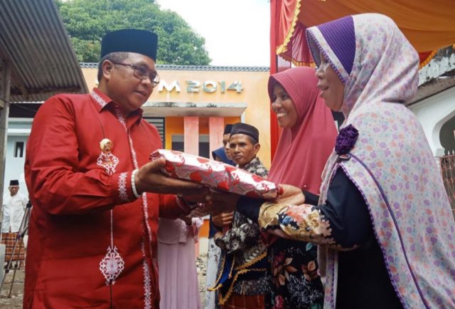 20181208_120710 Bupati Aceh Barat, H Ramli MS, menyerahkan bantuan puluhan mukena, sajadah dan Alquran kepada masyarakat di sela-ela pencanangan Kampung Muslimin yang dipusatkan di Desa Paya Baro, Kecamatan Woyla Timur, Kamis (6/12/2018). (Foto/Dedi Iskandar)