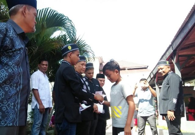 20181216_115051 Kalapas Klas II A Kota Lhokseumawe Nawawi menyaksikan napi kasus narkoba Wan dan Fad sedang membagikan amplop untuk menyantuni anak yatim pada acara Maulid Nabi di Lapas setempat, Sabtu (15/12/2018). (Foto/Zainuddin Abdullah)