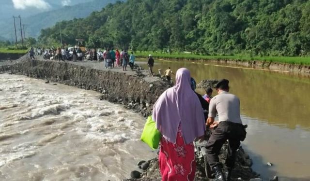WhatsApp Image 2018-12-02 at 13.06.09(1) Tampak petugas sedang membantu warga yang akan melintas jalan lintas Beureunuen-Meulaboh di kawasan Gampong Blang Bungong dan Blang Jeurat, yang kembali putus akibat diterjang air luapan sungai, Sabtu (1/12/2018). (Foto/Muhammad Riza)
