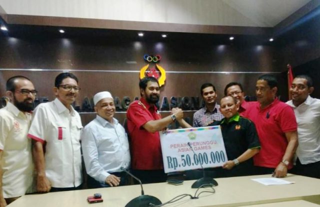 WhatsApp Image 2018-12-20 at 21.00.09 Ketum KONI Aceh Muzakir Manaf menyerahkan bonus secara simbolis, diterima T.Rayuan Sukma mewakili lifter peraih perunggu Asian Games, Surahmat, di KONI Aceh, Kamis (20/12/2018). (Foto/Aldin NL)